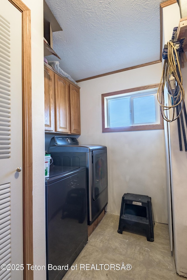 58 Blackhawk Trl, Boulder, WY 82923 - washroom with cabinet space, washing machine and dryer, crown molding, a textured ceiling, and light tile patterned floors