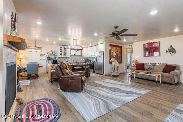 1516 Fischer Ln, Tetonia, ID 83452 - living room featuring light wood-type flooring, a ceiling fan, recessed lighting, a fireplace, and baseboards