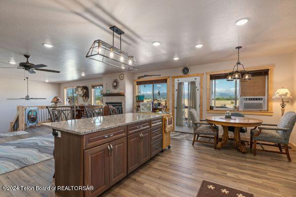 1516 Fischer Ln, Tetonia, ID 83452 - kitchen with a fireplace, recessed lighting, light wood-style flooring, ceiling fan, and light stone counters