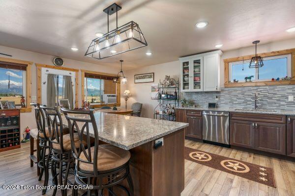 1516 Fischer Ln, Tetonia, ID 83452 - kitchen with stainless steel dishwasher, a sink, light stone countertops, light wood-style floors, and recessed lighting