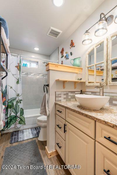 1516 Fischer Ln, Tetonia, ID 83452 - full bath featuring vanity, shower / tub combo with curtain, toilet, wood finished floors, and recessed lighting