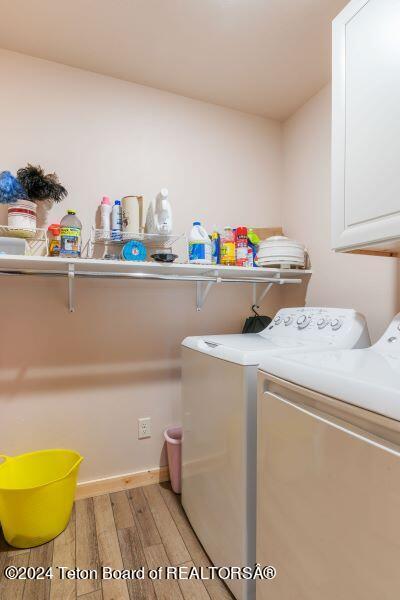 1516 Fischer Ln, Tetonia, ID 83452 - laundry area featuring cabinet space, light wood-type flooring, and washer and dryer
