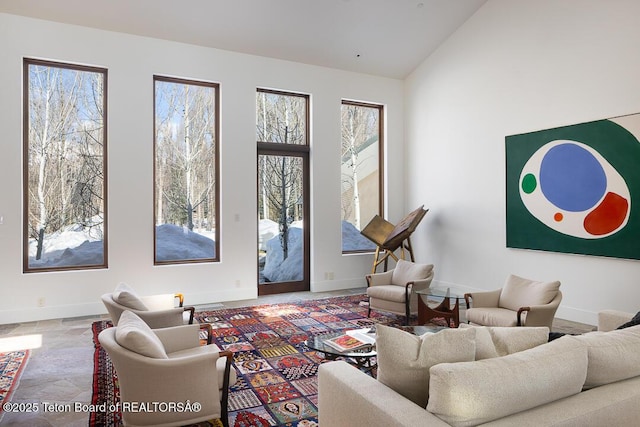 1120 S Thunder Rd, Wilson, WY 83014 - living area with plenty of natural light, baseboards, stone finish flooring, and lofted ceiling
