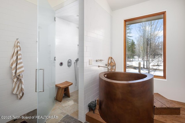 1120 S Thunder Rd, Wilson, WY 83014 - full bath featuring a stall shower, a soaking tub, stone finish floors, and tile walls