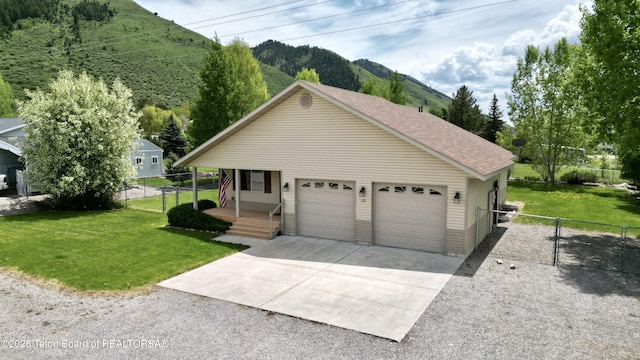 210 E 8th Ave, Afton, WY 83110 - view of front of property with a mountain view, covered porch, a gate, concrete driveway, and roof with shingles
