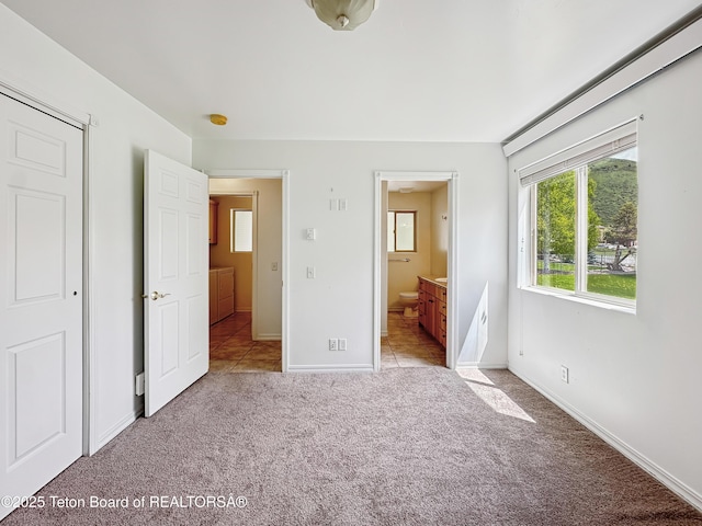 210 E 8th Ave, Afton, WY 83110 - unfurnished bedroom featuring carpet floors, baseboards, and ensuite bathroom
