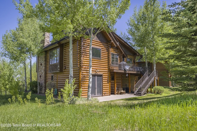 29 Bannock Cir, Victor, ID 83455 - back of property with stairs, a chimney, a wooden deck, a patio, and log exterior