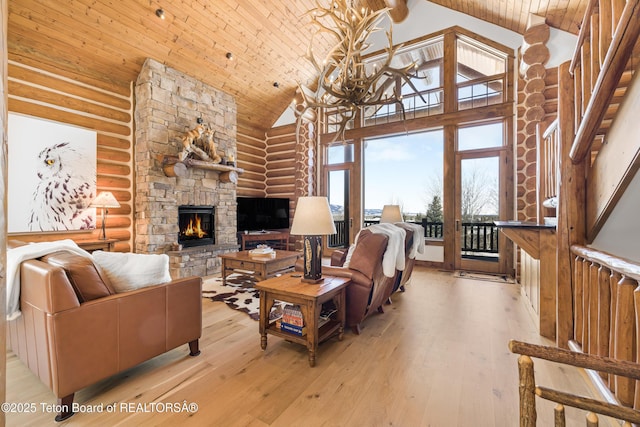 29 Bannock Cir, Victor, ID 83455 - living area with rustic walls, high vaulted ceiling, a fireplace, light wood-style flooring, and wood ceiling with exposed beams