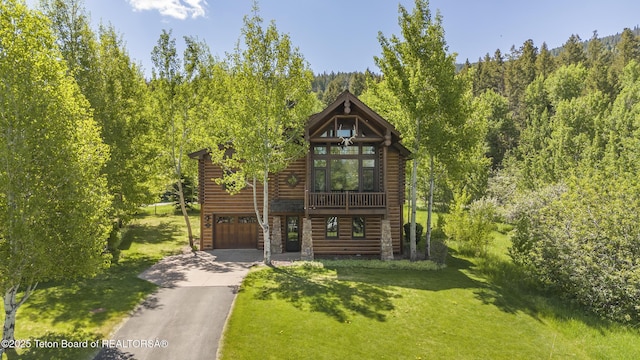 29 Bannock Cir, Victor, ID 83455 - view of front of property featuring asphalt driveway, a front yard, log veneer siding, and an attached garage