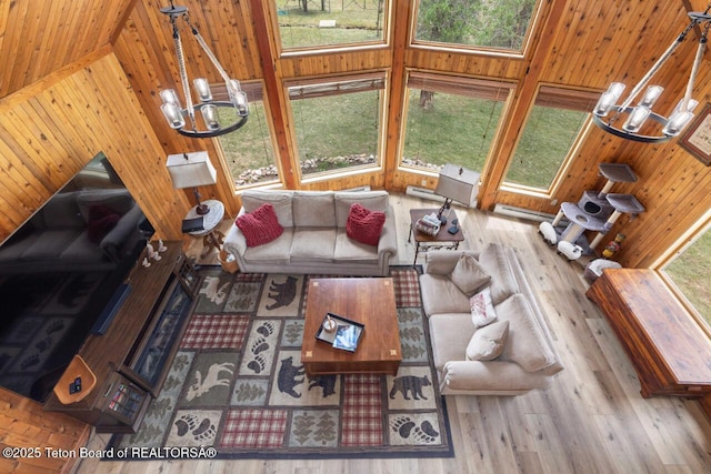 205 Betsy Ct, Bedford, WY 83112 - living room with a chandelier, wood walls, and wood finished floors