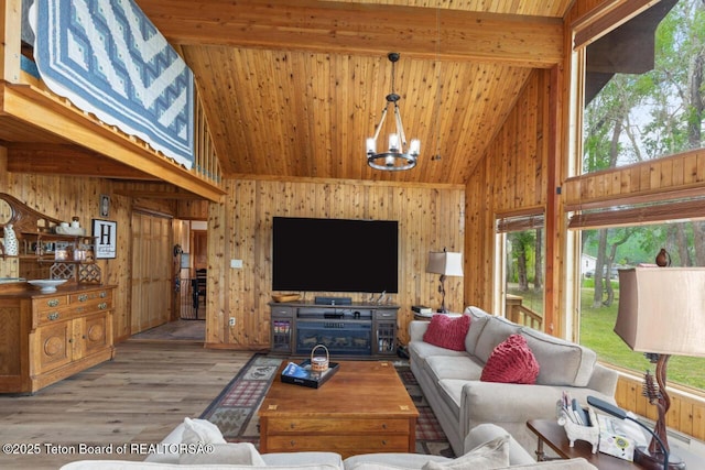 205 Betsy Ct, Bedford, WY 83112 - living room with high vaulted ceiling, healthy amount of natural light, a chandelier, wooden walls, and wood finished floors