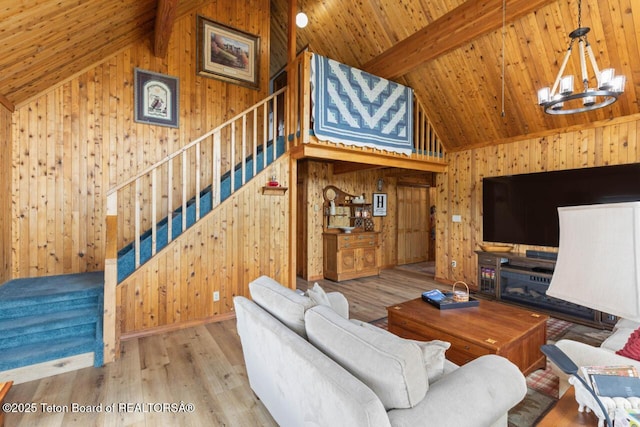 205 Betsy Ct, Bedford, WY 83112 - living area featuring wood walls, a chandelier, stairs, wood ceiling with exposed beams, and wood finished floors
