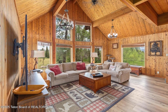 205 Betsy Ct, Bedford, WY 83112 - living room with a chandelier, wooden walls, wooden ceiling with exposed beams, wood finished floors, and high vaulted ceiling