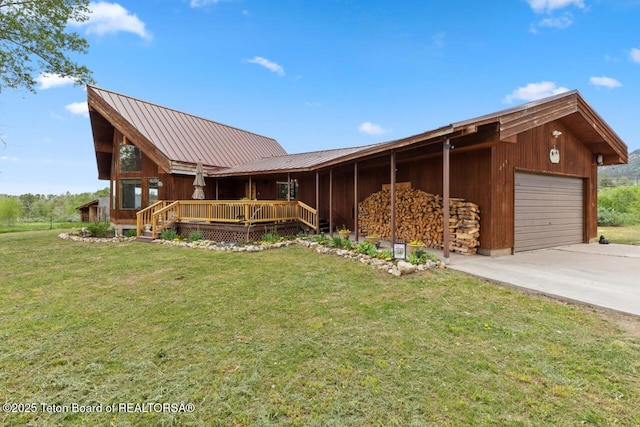 205 Betsy Ct, Bedford, WY 83112 - view of front facade with concrete driveway, a front lawn, metal roof, and a wooden deck