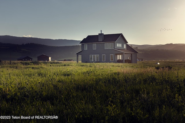 6118 Hatfield Way, Driggs, ID 83422 - back of house at dusk with a chimney and a mountain view