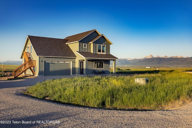 6118 Hatfield Way, Driggs, ID 83422 - view of front of house with an attached garage, driveway, a mountain view, board and batten siding, and a porch