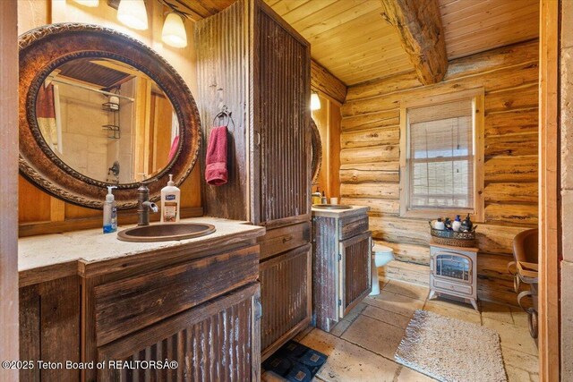 62 Skyline Dr, Bondurant, WY 82922 - bathroom with wood ceiling with exposed beams, log walls, vanity, toilet, and a shower