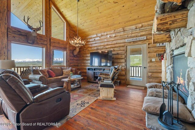 62 Skyline Dr, Bondurant, WY 82922 - living room with a warm lit fireplace, high vaulted ceiling, rustic walls, wood finished floors, and wood ceiling