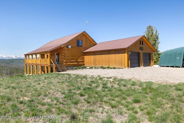 62 Skyline Dr, Bondurant, WY 82922 - view of side of property featuring a detached garage, log siding, an outbuilding, and metal roof