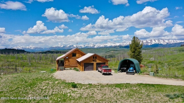 62 Skyline Dr, Bondurant, WY 82922 - view of front of home with a mountain view, an outbuilding, gravel driveway, and a garage