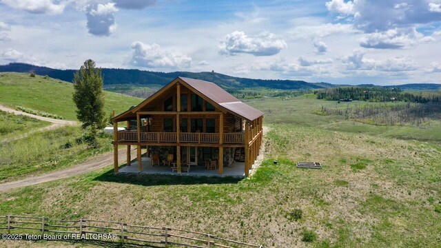 62 Skyline Dr, Bondurant, WY 82922 - back of property featuring a wooden deck, a patio area, log exterior, a view of rural / pastoral area, and stone siding