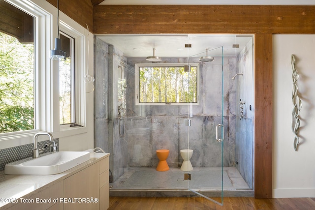 2540 Trader Rd, Jackson, WY 83001 - full bath featuring a marble finish shower, vanity, wood finished floors, and tasteful backsplash