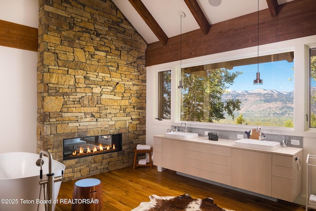 2540 Trader Rd, Jackson, WY 83001 - full bath with a soaking tub, wood finished floors, a stone fireplace, and plenty of natural light