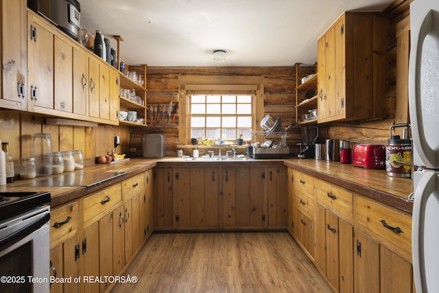 4075 Jarvis Ln, Wilson, WY 83014 - kitchen with open shelves, rustic walls, a sink, light wood finished floors, and stainless steel range