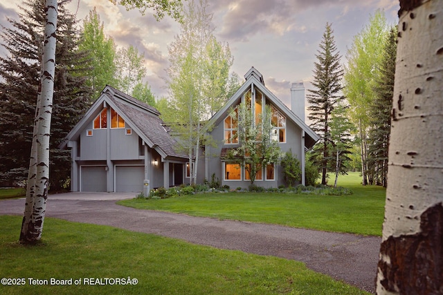 3065 N Mountain Maple Ln, Wilson, WY 83014 - view of front of house with a chimney, a front lawn, driveway, and a garage
