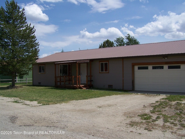 6 Opal St, Pinedale, WY 82941 - single story home with an attached garage, dirt driveway, a metal roof, and covered porch