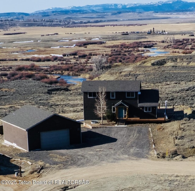 21 Hawk Path, Boulder, WY 82923 - view of front of property with a mountain view, an outdoor structure, driveway, a detached garage, and view of desert