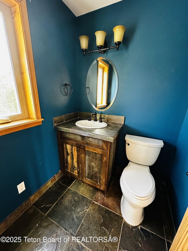 21 Hawk Path, Boulder, WY 82923 - half bath with vanity, baseboards, toilet, and stone finish floors