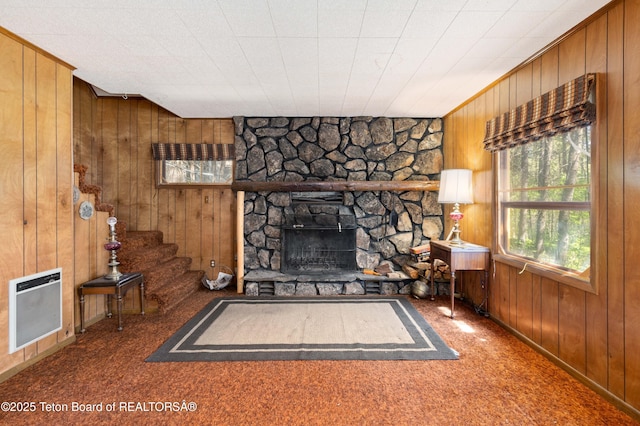 739 Pinecrest, Alpine, WY 83128 - unfurnished living room with heating unit, wood walls, a stone fireplace, carpet floors, and stairs