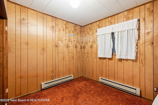 739 Pinecrest, Alpine, WY 83128 - carpeted spare room featuring baseboard heating and wood walls