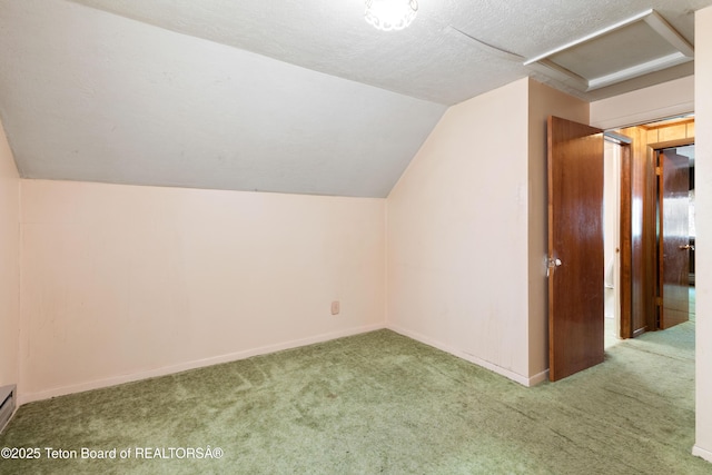 739 Pinecrest, Alpine, WY 83128 - additional living space featuring attic access, carpet, vaulted ceiling, baseboards, and a textured ceiling