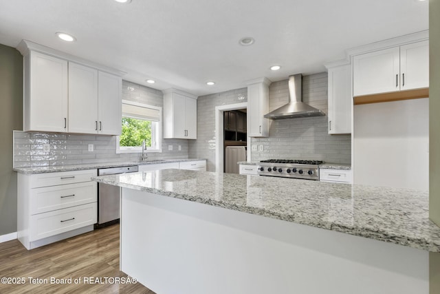 560 Appaloosa Trl, Driggs, ID 83422 - kitchen featuring wall chimney exhaust hood, stainless steel dishwasher, range, white cabinetry, and a sink
