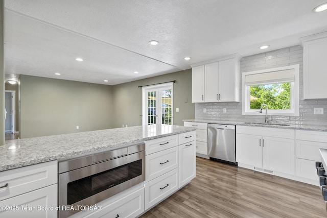 560 Appaloosa Trl, Driggs, ID 83422 - kitchen with appliances with stainless steel finishes, a sink, recessed lighting, backsplash, and white cabinets