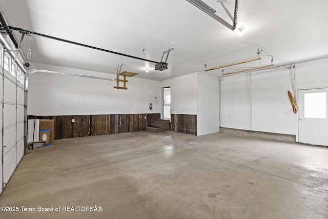 560 Appaloosa Trl, Driggs, ID 83422 - garage with a garage door opener, a wainscoted wall, and wood walls