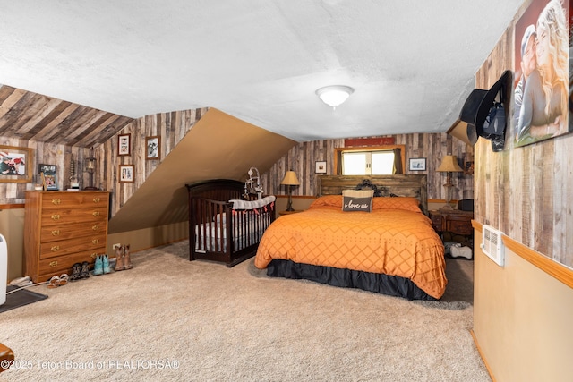 105 Heap Dr, Thayne, WY 83127 - bedroom featuring carpet flooring, vaulted ceiling, wood walls, and a textured ceiling