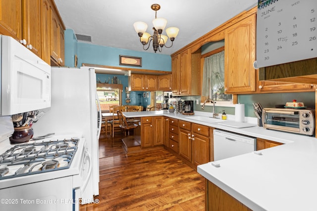 105 Heap Dr, Thayne, WY 83127 - kitchen featuring white appliances, a sink, a peninsula, a chandelier, and wood finished floors