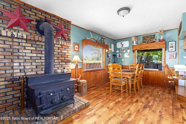 105 Heap Dr, Thayne, WY 83127 - dining room featuring a wood stove, wood finished floors, a wainscoted wall, and wood walls
