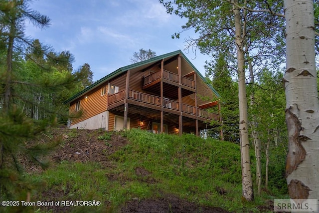 4770 Deer Dr, Island Park, ID 83429 - back of property featuring log veneer siding, a deck, and a garage