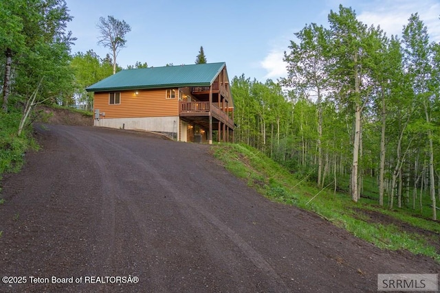 4770 Deer Dr, Island Park, ID 83429 - chalet / cabin with driveway, a wooden deck, and metal roof