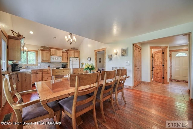4770 Deer Dr, Island Park, ID 83429 - dining area with a chandelier, light wood-style flooring, lofted ceiling, and baseboards
