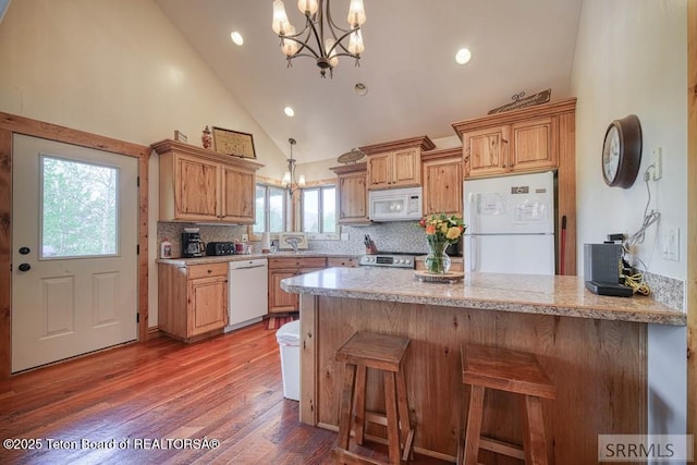 4770 Deer Dr, Island Park, ID 83429 - kitchen featuring white appliances, a chandelier, a peninsula, high vaulted ceiling, and backsplash
