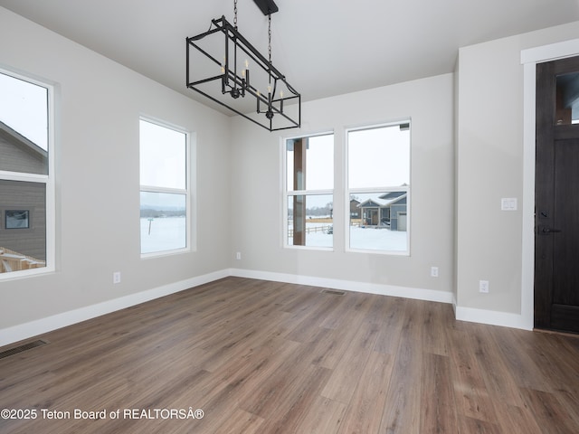 311 Bald Eagle Dr, Victor, ID 83455 - unfurnished dining area with a chandelier, healthy amount of natural light, wood finished floors, and baseboards