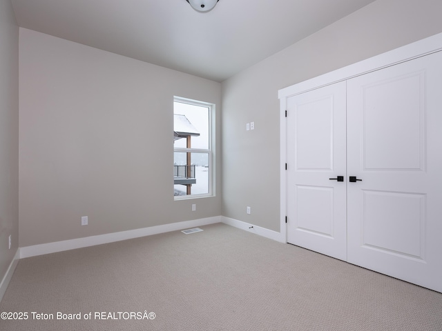 311 Bald Eagle Dr, Victor, ID 83455 - unfurnished bedroom with light carpet, baseboards, and a closet