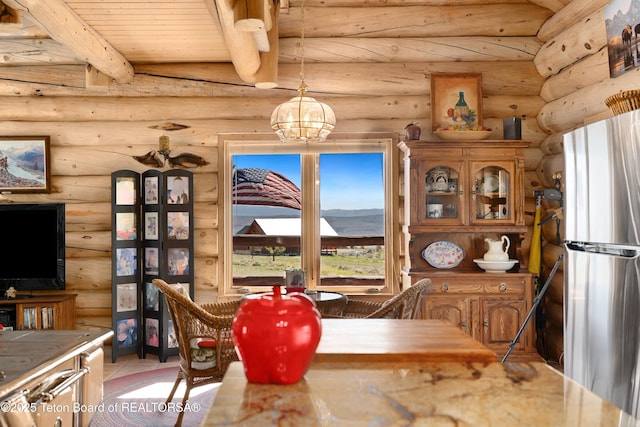 196 Soda Springs Dr, Dubois, WY 82513 - dining area featuring rustic walls, a chandelier, a wood ceiling with exposed beams, and tile patterned flooring