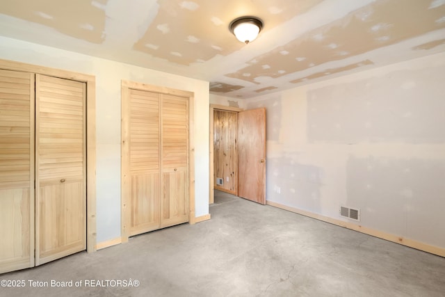 196 Soda Springs Dr, Dubois, WY 82513 - unfurnished bedroom featuring two closets and concrete floors