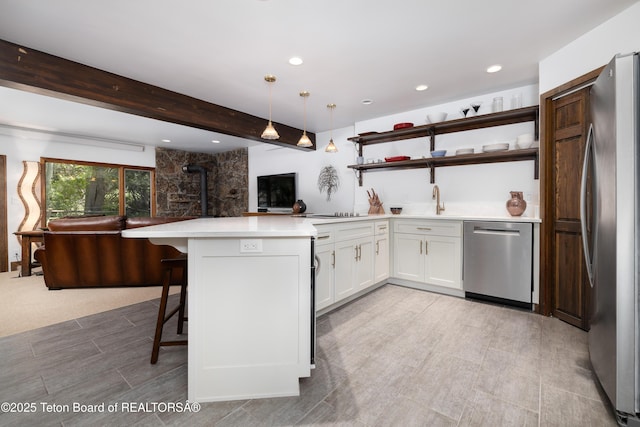 450 E Sagebrush Dr Unit 3-1-A, Jackson, WY 83001 - kitchen featuring stainless steel appliances, a peninsula, open shelves, white cabinets, and light countertops